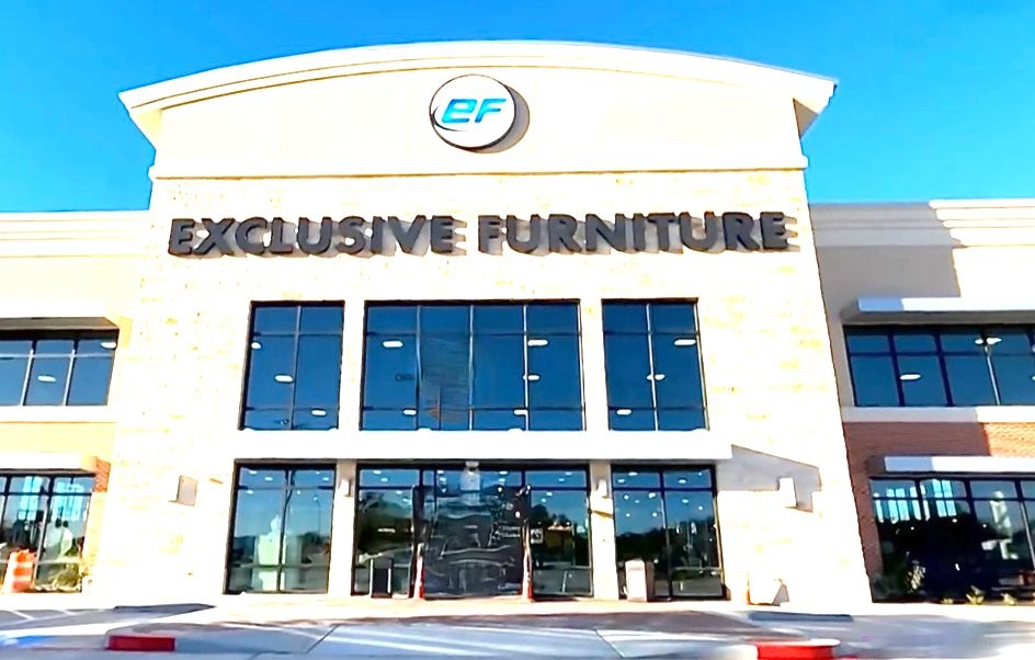 Exclusive Furniture flagship store with stone facade and dark-framed glazing