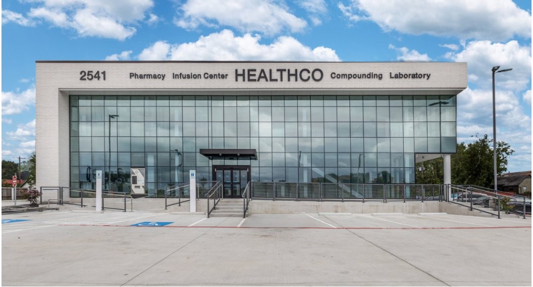 HEALTHCO Pharmacy and Infusion Center storefront with two-story curtain wall facade